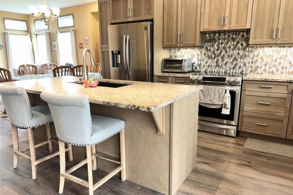 View of the kitchen island from the dining area, showing granite countertop and pendant lights above. - 27123 Park 70n Road, Springfield Rm