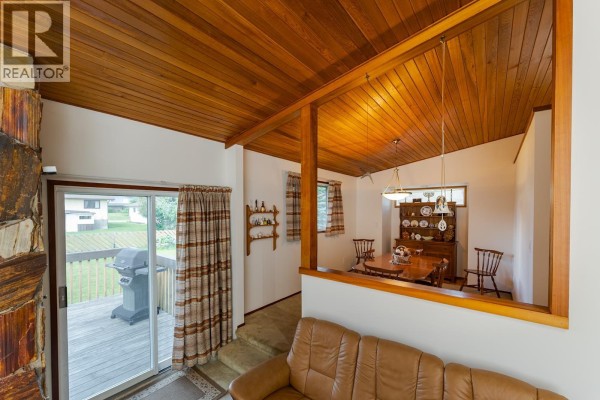 Interior view showing a dining area, living room, and sliding door to a deck. - 2715 Wildwood Crescent, Prince George