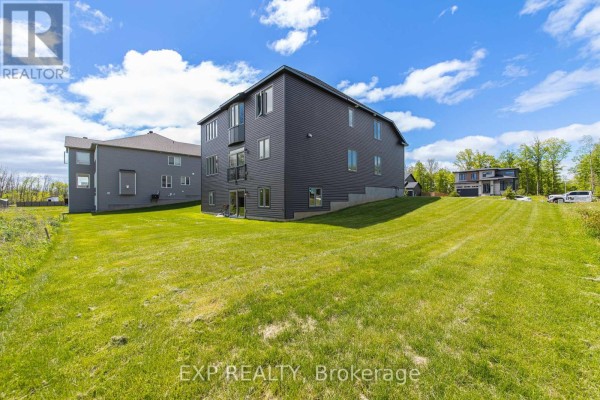 Aerial view of the dark grey house with a large green backyard. - 272 Antler Court, Mississippi Mills
