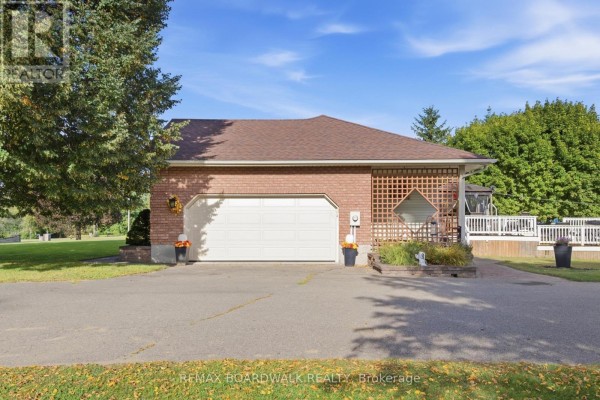 Attached two-car garage with a white door, brick exterior, and asphalt driveway. - 2725 Mcintosh Road, Augusta