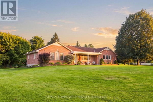 Brick bungalow with a covered porch and backyard view during sunset. - 2725 Mcintosh Road, Augusta