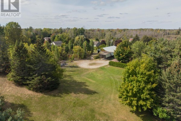 Aerial view of a large property with a house, garage, and wooded areas. - 2725 Mcintosh Road, Augusta