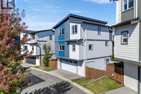 Aerial view of the rear of a modern townhouse complex on a paved street. - 2728 Celestial Crt, Langford