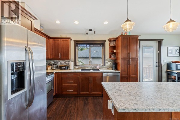 Kitchen with dark wood cabinets, stainless steel appliances, and a large island - 2735 Rydal Ave, Cumberland