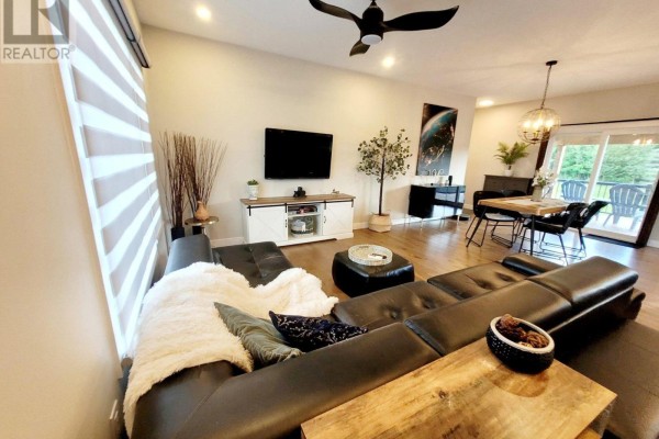 Living and dining area with a black sectional, wood furniture, and patio doors. - 274 Roxanne Street, Clarence Rockland