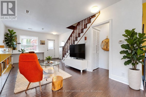 Living room showing staircase, entry door, and open concept kitchen. - 274 Wallace Avenue, Toronto