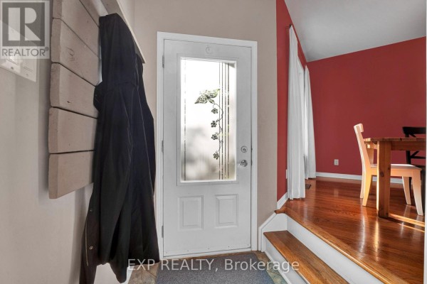 Interior entryway with a frosted glass door, coat rack, and red accent wall. - 2744 Sylvain Street, Clarence Rockland
