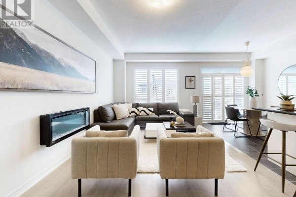 A spacious living room with a sectional sofa, a fireplace, two accent chairs, and large windows with white shutters. - 2747 Peter Matthews Drive, Pickering