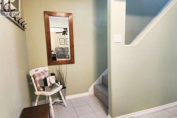 Finished basement room with a desk, office chairs, exercise equipment, and storage closets. - 275 10th Avenue, Montrose