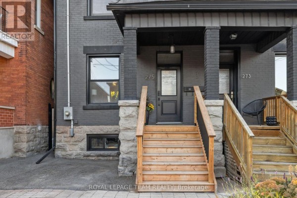 Close-up of the front entrance of a dark grey home with wooden steps and stone foundation. - 275 Arlington Avenue, Ottawa