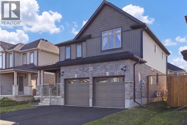 Side view of a modern two-story house with a gray facade, stone accents, and a double garage. - 275 Bradshaw Drive, Stratford