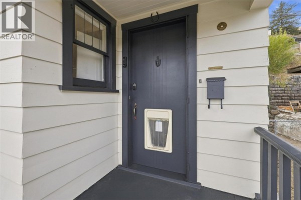 Detailed view of the dark gray front door of the house, with a small window above and a mail slot near the bottom. - 275 Seymour  W Street, Kamloops