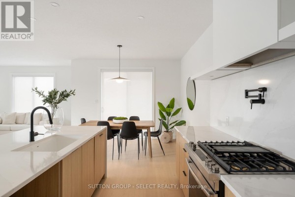 View of an open-concept kitchen and dining area with a large island. - 275 Silver Maple Circle, Thames Centre