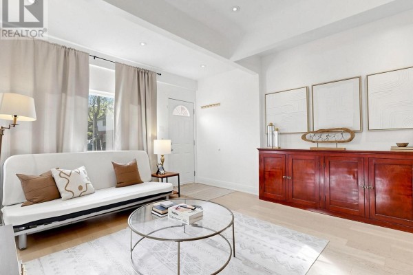 Living room with white futon, glass coffee table, and large dark wood sideboard. - 275 Victoria Park Avenue, Toronto