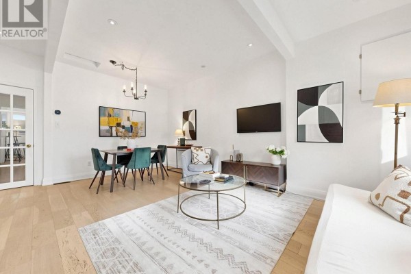 Living and dining area with teal chairs, table, futon, and glass door to kitchen. - 275 Victoria Park Avenue, Toronto