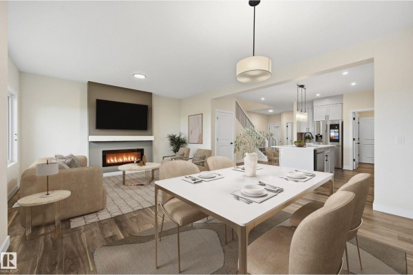 View of the living room, dining area, and kitchen from the dining room table. - 276 Lodge Pole Pl, Leduc