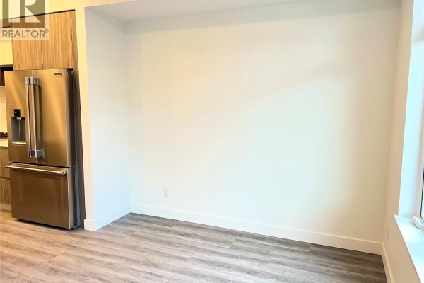 Dining area adjacent to the kitchen with a blank wall and wood-look flooring. - 2760 Olalla Road Unit# 407, West Kelowna