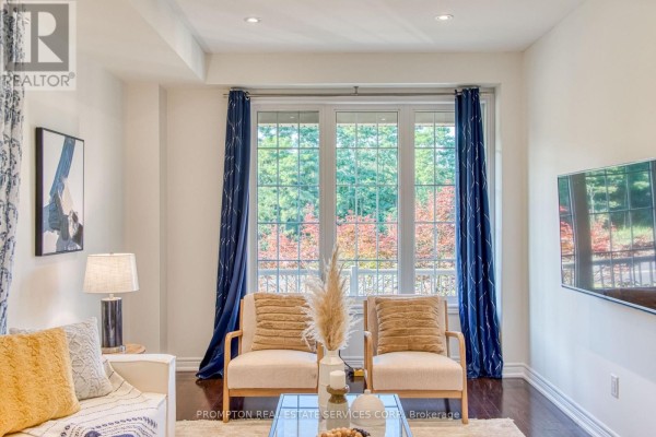 View of a window with blue curtains looking out onto trees with red and green foliage. - 2762 Donald Cousens Parkway, Markham