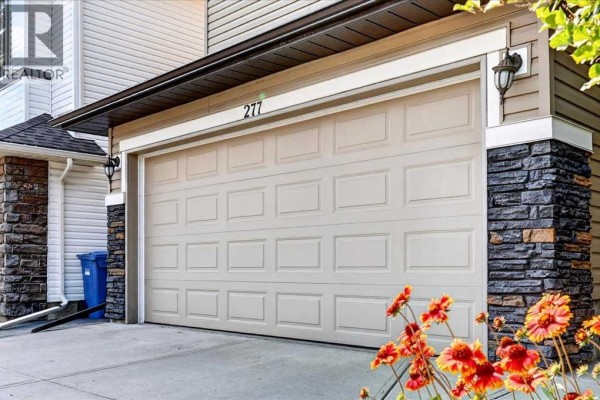 Close-up of the garage door at 277 Evermeadow Avenue SW, Calgary, with stone accents. - 277 Evermeadow Avenue Sw, Calgary