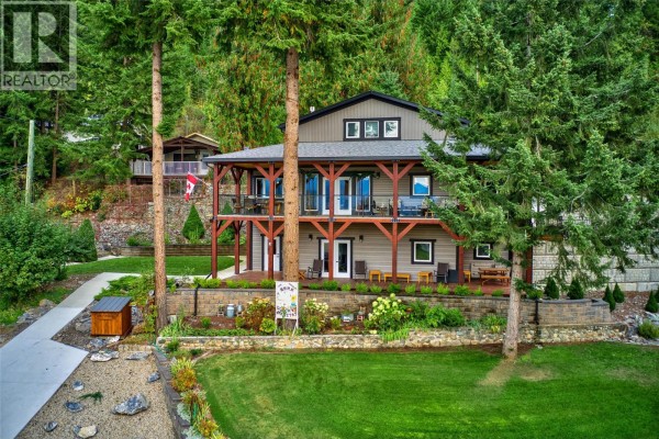 Cozy living room featuring leather seating, hardwood floors, and access to the deck. - 2770 Perris Road, Blind Bay