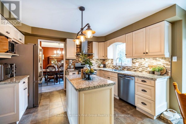 Kitchen with light wood cabinets, granite countertops, island, and view to dining room. - 278 St Joseph Road, Kawartha Lakes
