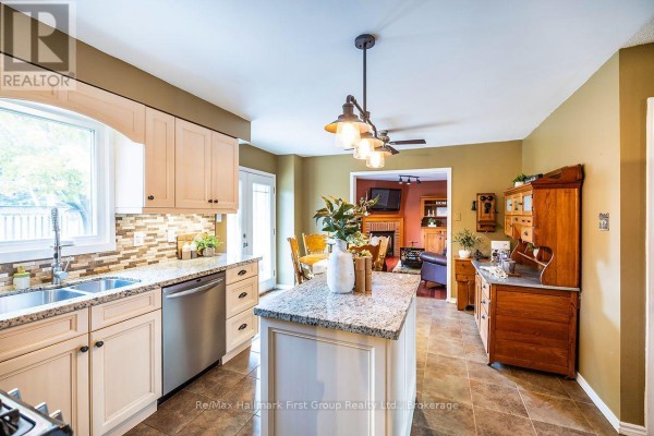 Kitchen with light wood cabinets, granite island, stainless steel appliances, and view to living room. - 278 St Joseph Road, Kawartha Lakes