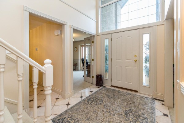 Entrance foyer with a white double door, staircase, and doorway to an office. - 2780 St Moritz Way, Abbotsford
