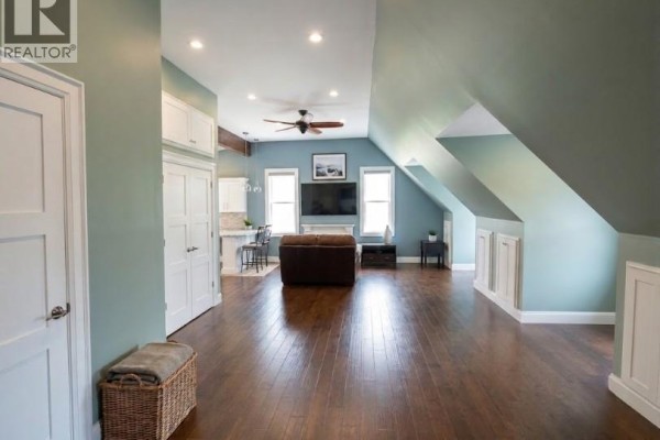 Open concept living area with a small kitchen, sofa, and mounted television. - 2784 South Grimsby Rd 20 Unit# Upper, West Lincoln