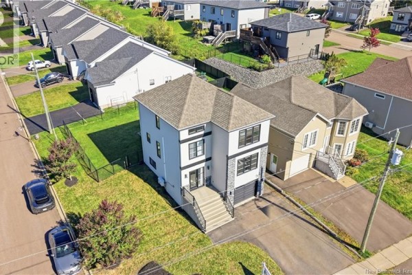 Aerial view of a tall, narrow house with a grey and white exterior and surrounding neighborhood. - 279 Freeman, Moncton