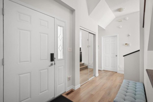 Dining area with a modern table and chairs, large window with view of houses, and a stainless steel refrigerator. - 279 Reg Wyatt Way, Winnipeg