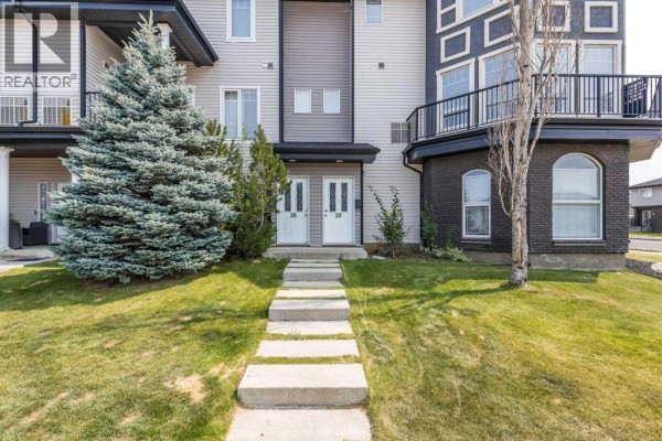 Stone pathway leading to two identical front doors of the townhouse units. - 28, 298 Somerset Way Se, Medicine Hat