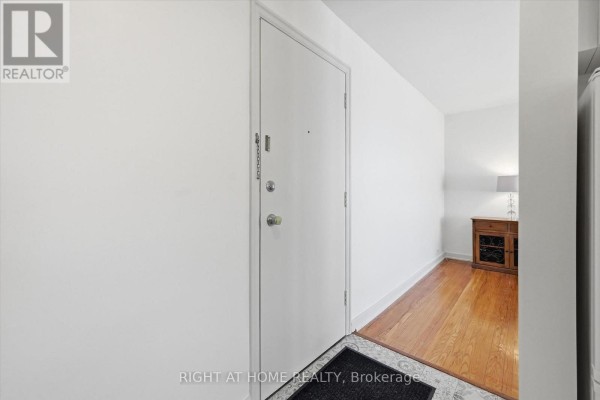 Interior hallway with white walls, beige door, and wooden floor. - 28 - 137 Emerald Street S, Hamilton