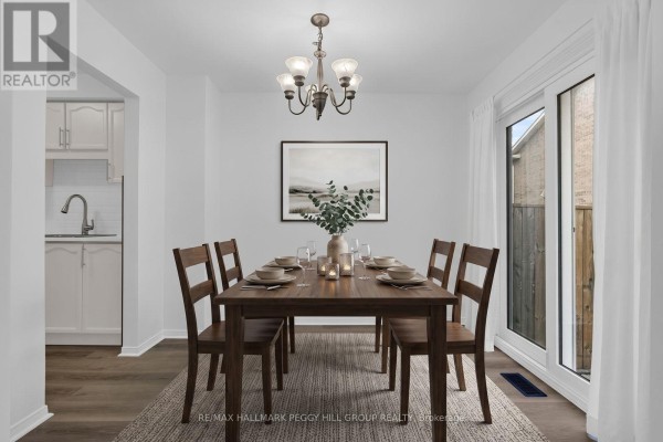 Dining room with a dark wood table, six chairs, chandelier, and sliding glass door. - 28 - 165 Kozlov Street, Barrie