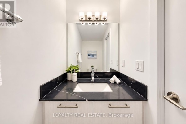 Bathroom vanity with black countertop, undermount sink, and a mirror above. - 28 - 861 Sheppard Avenue W, Toronto