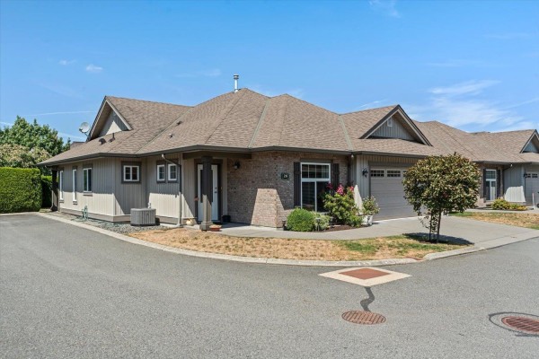 Side view of a townhouse complex with manicured landscaping and trees. - 28 45752 Stevenson Road, Sardis South, Chilliwack