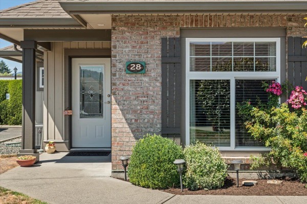 Close-up of the front entrance of a townhouse with a white door and brick facade. - 28 45752 Stevenson Road, Sardis South, Chilliwack