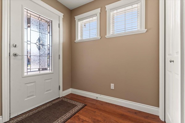 Interior entryway with a glass-paneled door, hardwood floors, and tan walls. - 28 45752 Stevenson Road, Sardis South, Chilliwack