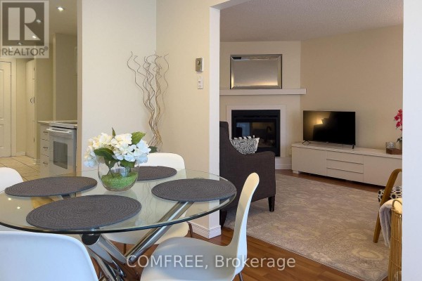 Dining area with view of living room fireplace, television, and media console. - 28 Bluejay Drive, Barrie
