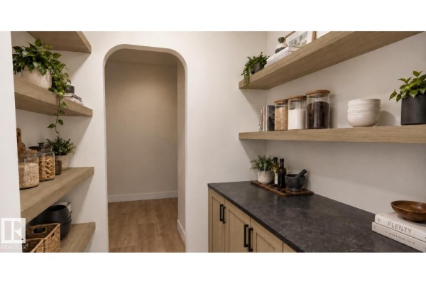 Walk-in pantry with open shelving, wood cabinetry, and an arched doorway. - 28 Brickyard Vw, Stony Plain