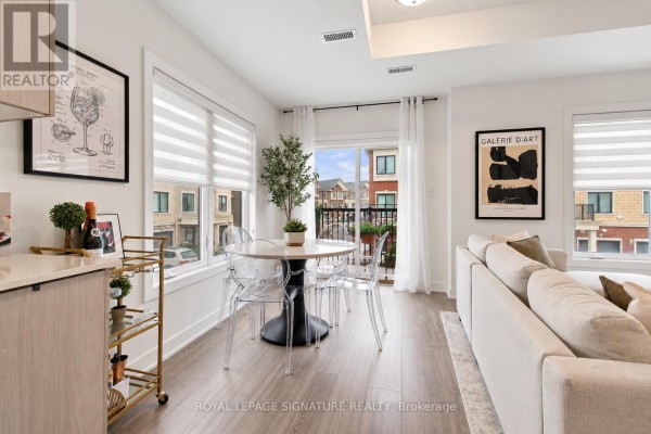 Dining area with a round table and chairs, adjacent to a balcony with outdoor seating. - 28 Canton Lane, Whitchurch Stouffville