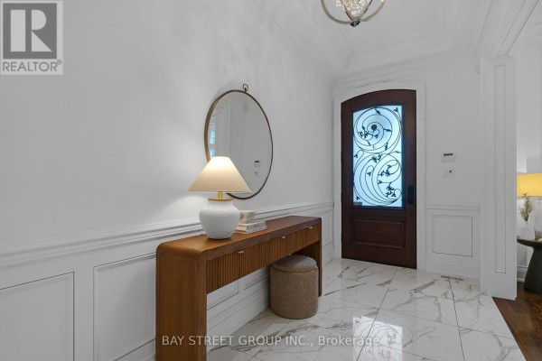 Hallway with marble tile floors, connecting to living and dining rooms. - 28 Carnwath Crescent, Toronto