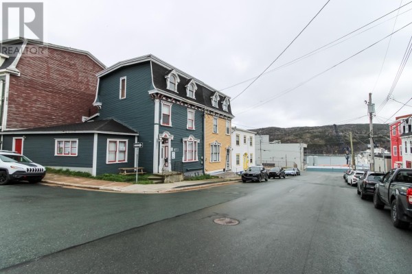A white ceiling with ornate molding, a central medallion, and a brass chandelier. - 28 Cochrane Street, St  John S