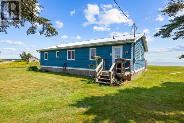 A spacious kitchen with grey cabinets, butcher block counter, stainless steel appliances, and wood floors. - 28 Gordons Way, Augustine Cove