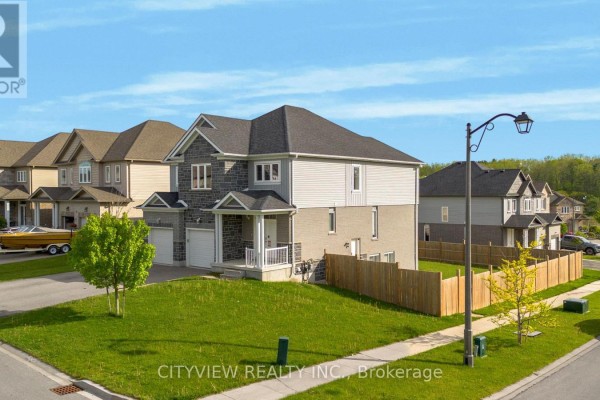 Side aerial view of a grey and stone duplex with a wooden fenced backyard. - 28 Hartfield Street, Ingersoll