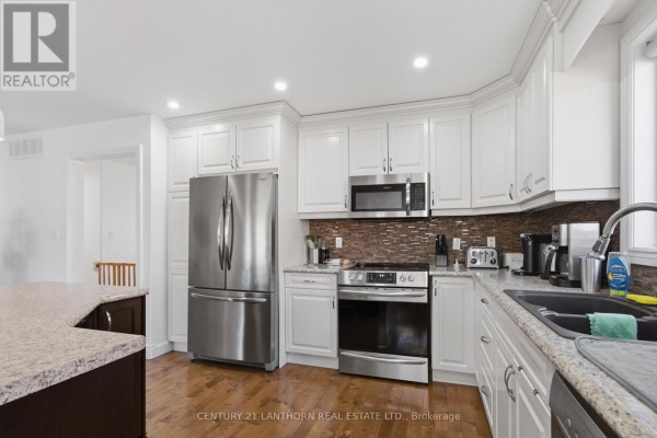 Renovated kitchen with white cabinets, granite countertops, stainless steel appliances - 28 Hickory Grove Belleville