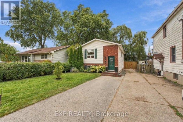 A residential house with a driveway and green lawn under a blue sky with scattered clouds. - 28 Maitland Street, Thorold