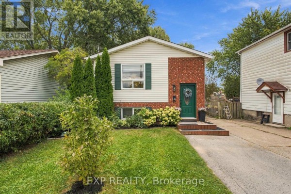 Front exterior of a modest two-story house with a well-kept lawn and landscaping. - 28 Maitland Street, Thorold