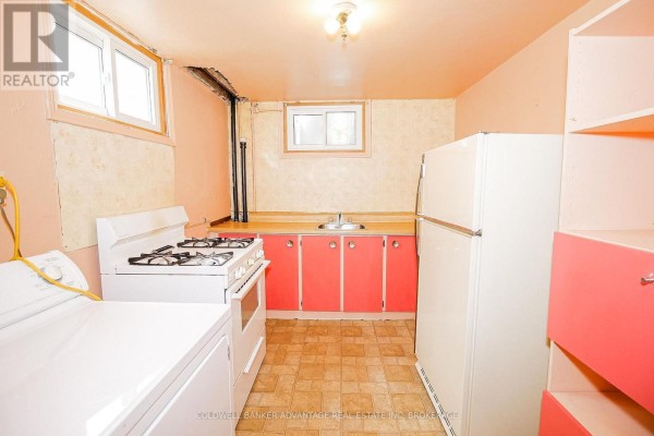 Kitchen with white appliances, red cabinets, and tiled backsplash - 28 Marshall Avenue Welland