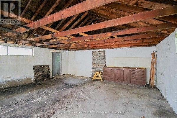Garage interior with exposed beams, metal cabinets, concrete floor - 28 Marshall Avenue Welland