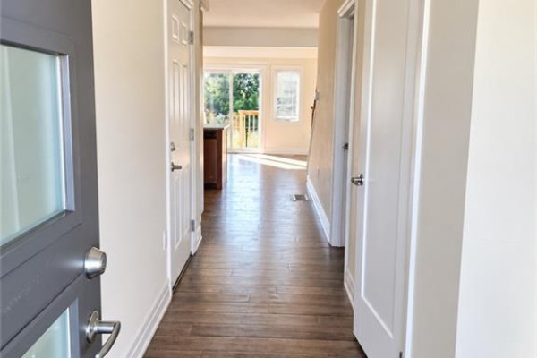 View from the front door into a home's hallway with hardwood floors. - 28 Nieson Street, Cambridge